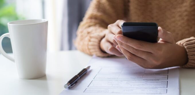 Dueño de pyme revisa un formulario y el celular para adherir al plan de pagos ARCA de la RG 5875/2026.